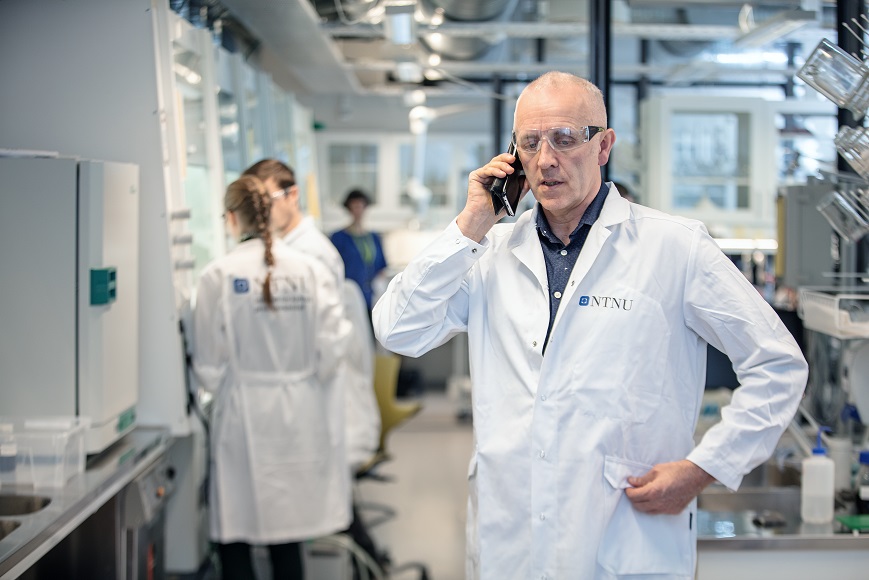 Magnar Bjørås som står på laben og snakker i telefonen.